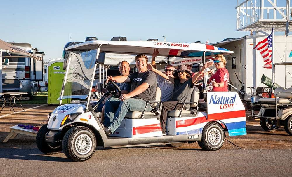 Friends sharing laughter and anticipation on a Joyride race fan shuttle