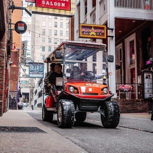 Tourists inside a red golf cart